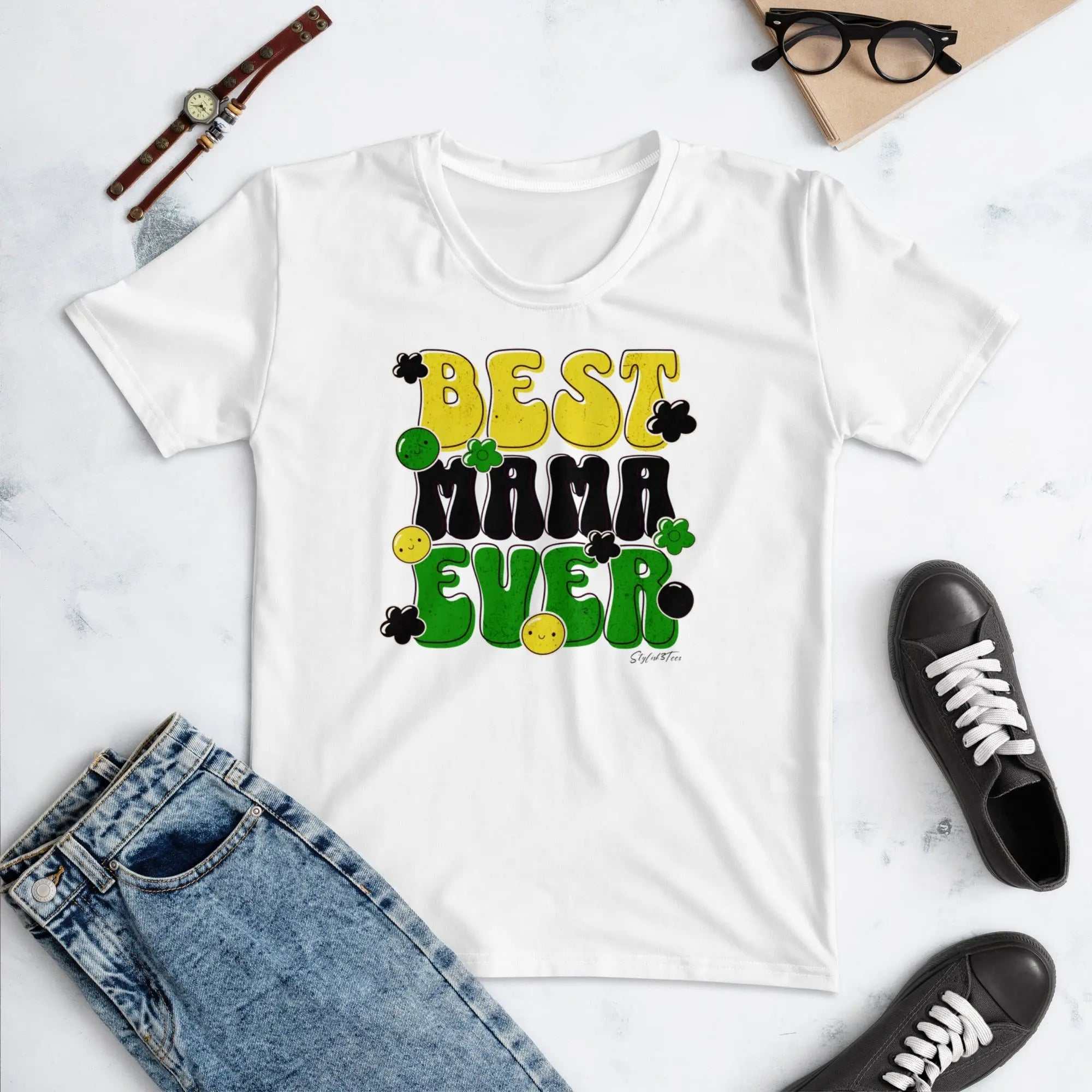 White Mothers Day Women's T-Shirt with "Best Mama Ever" graphic, laid flat with denim jeans and black sneakers.