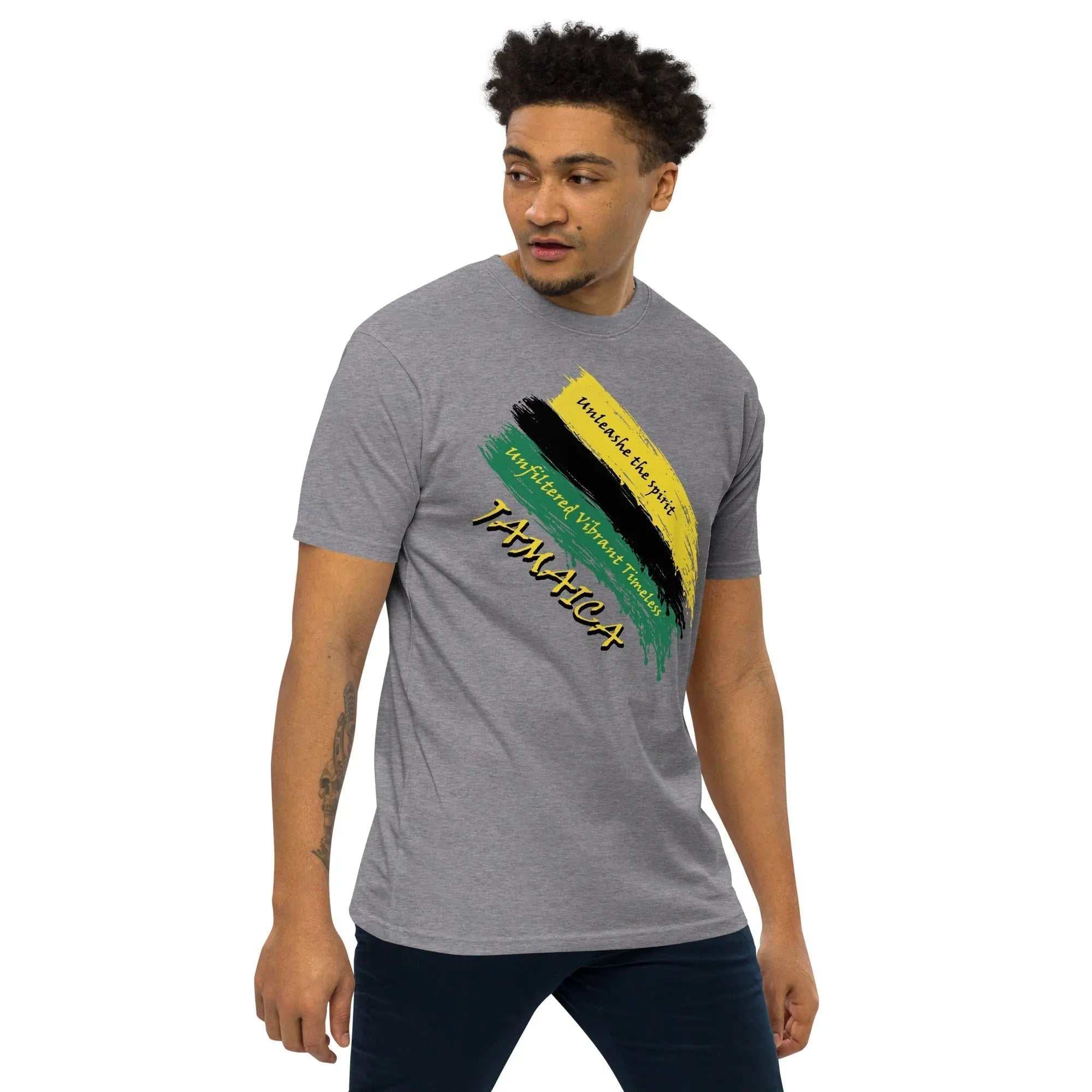 Raw Unfiltered Jamaica Men’s Premium Heavyweight Tee with black, green, and gold brush stroke design and "Unshake the Spirit" text on charcoal gray fabric