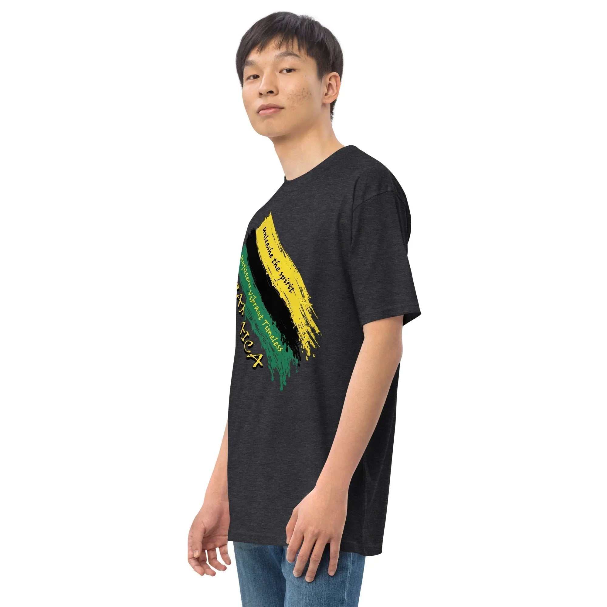 Man wearing Raw Unfiltered Jamaica men’s premium heavyweight tee with diagonal brush strokes in black, green, and gold colors and "Unshake the Spirit" text