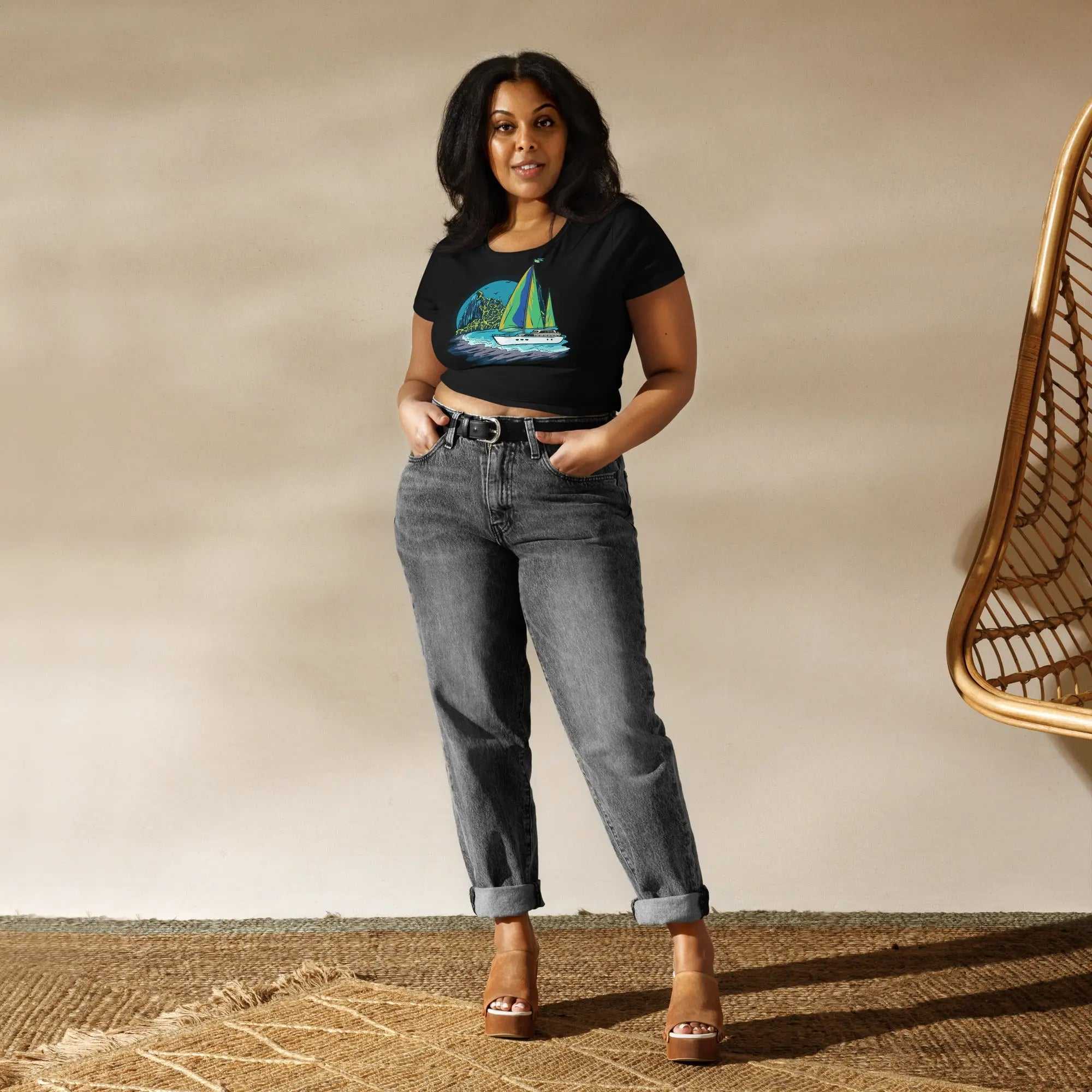 Woman wearing Caribbean Paradise Women s Crop Tee with sailboat graphic and high-waisted jeans