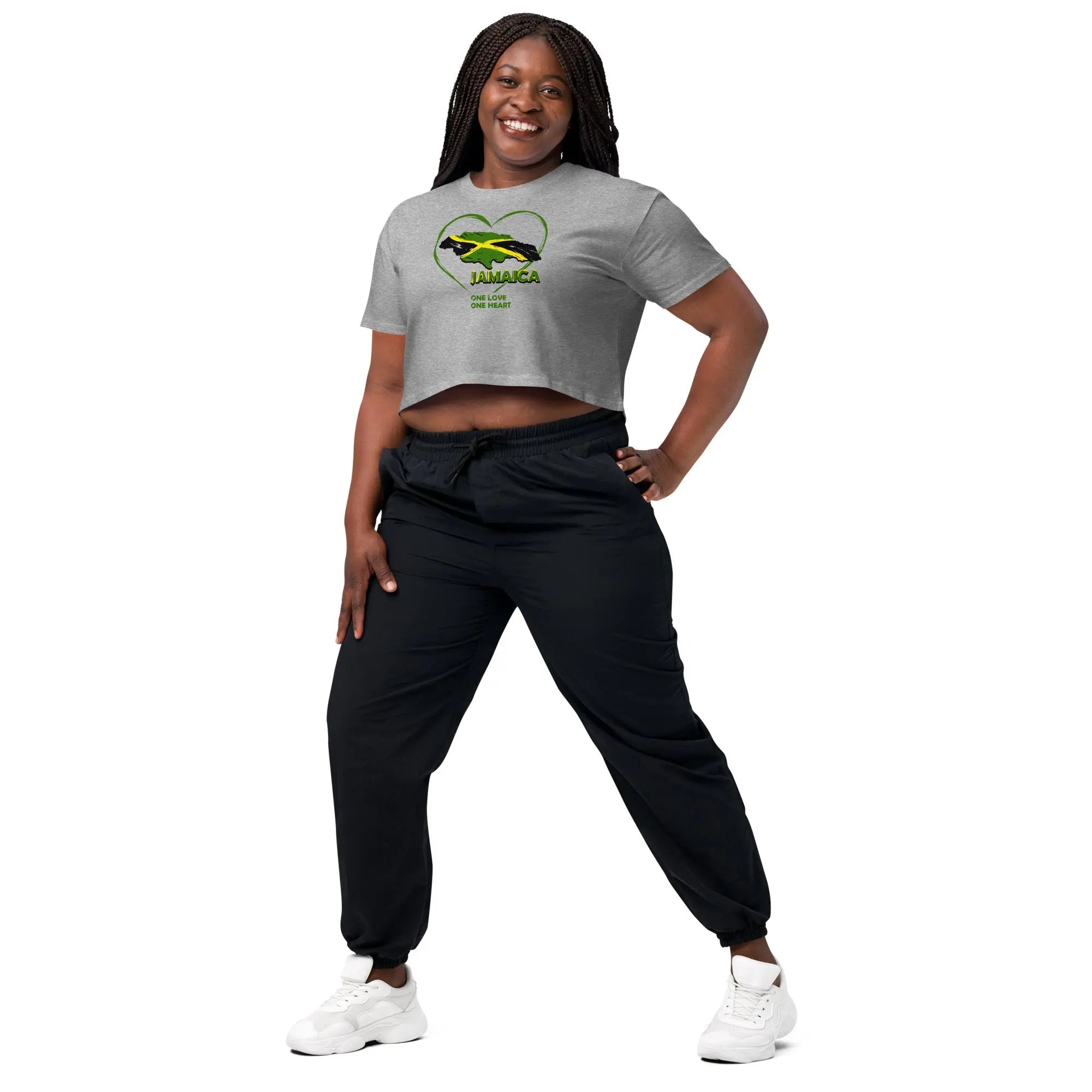 Woman wearing gray One Love One Heart crop top with Jamaican flag heart design and black pants