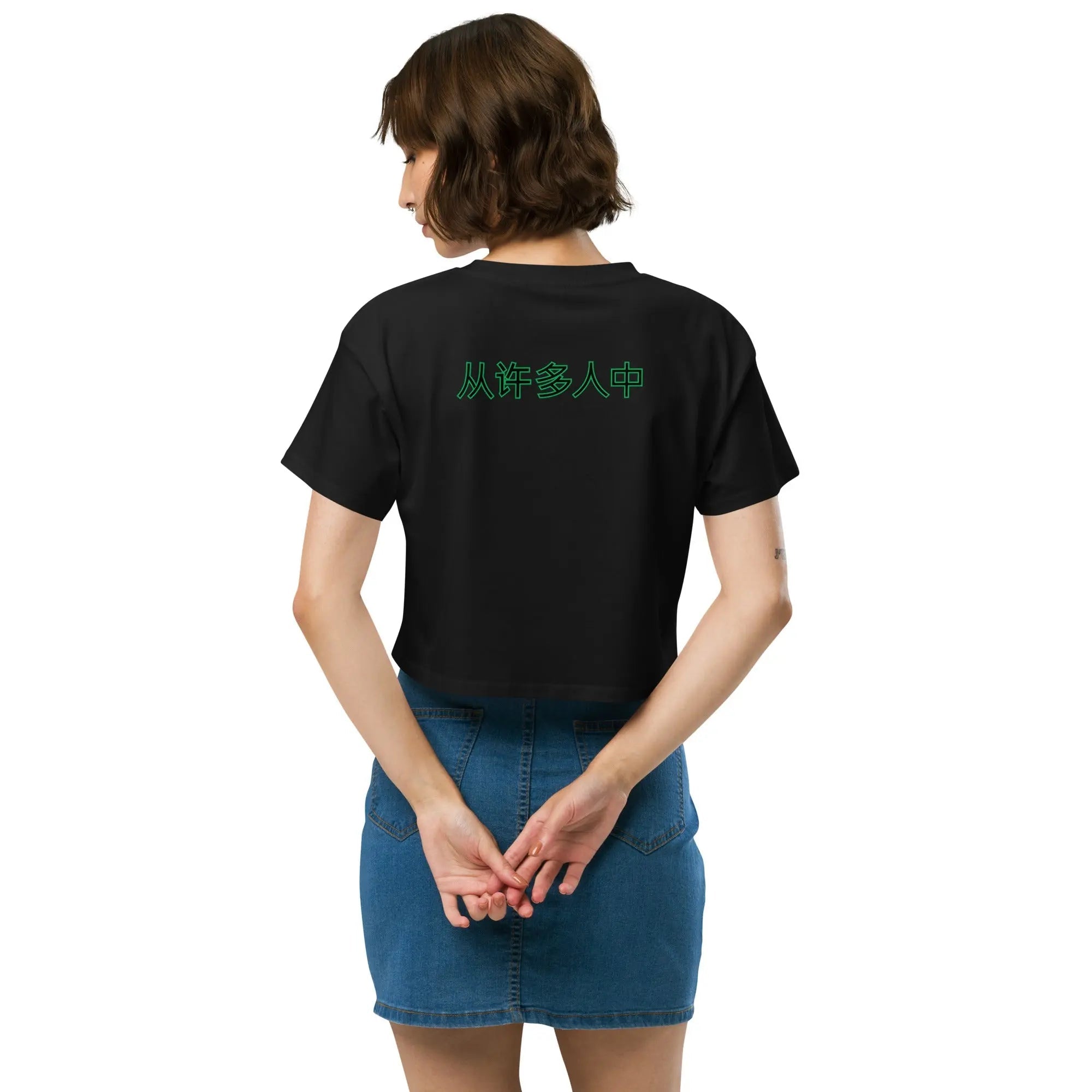 Out Of Many One People women’s black crop top with green Chinese characters on back, relaxed fit, paired with denim skirt