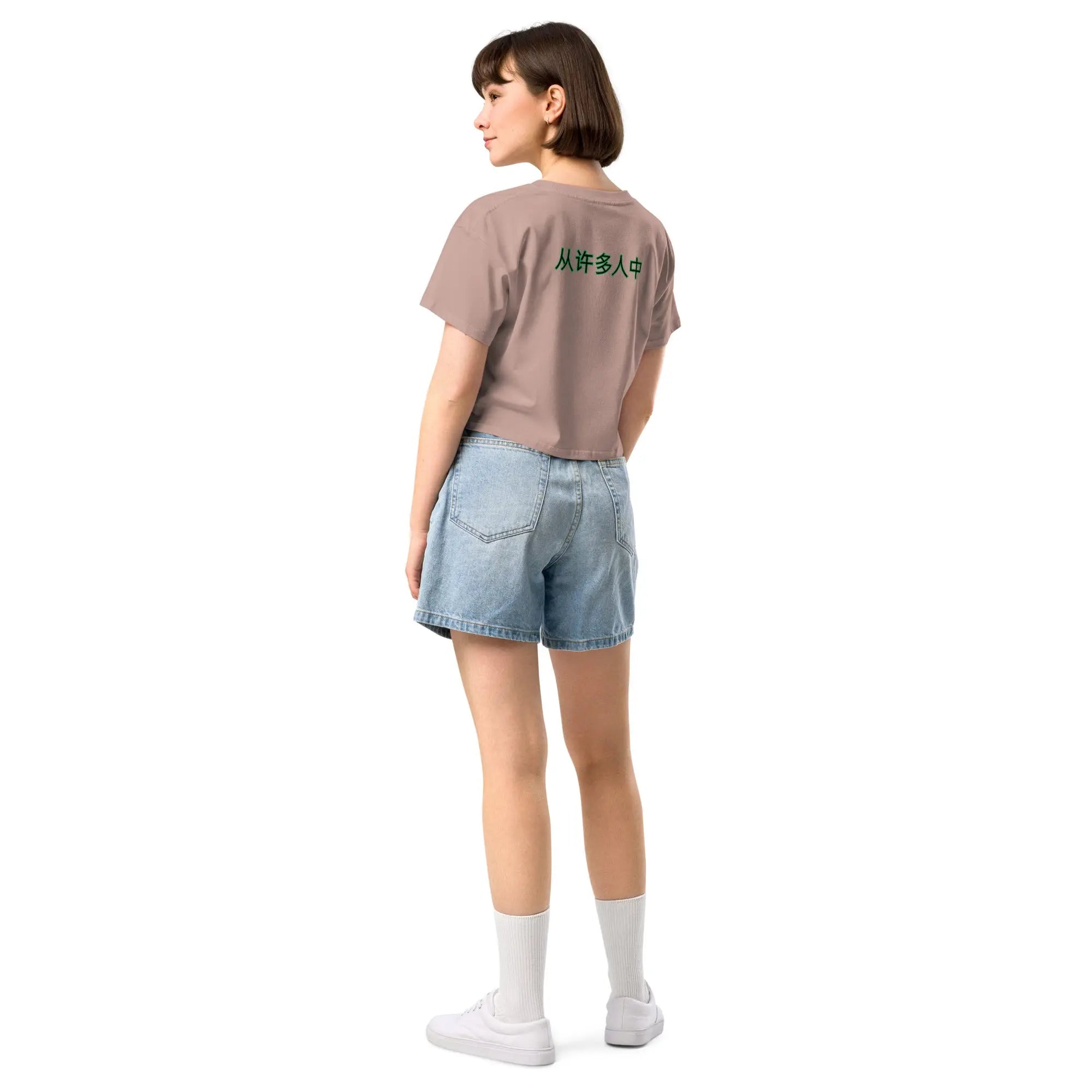 Woman wearing Out Of Many One cropped women's brown t-shirt and denim shorts back view