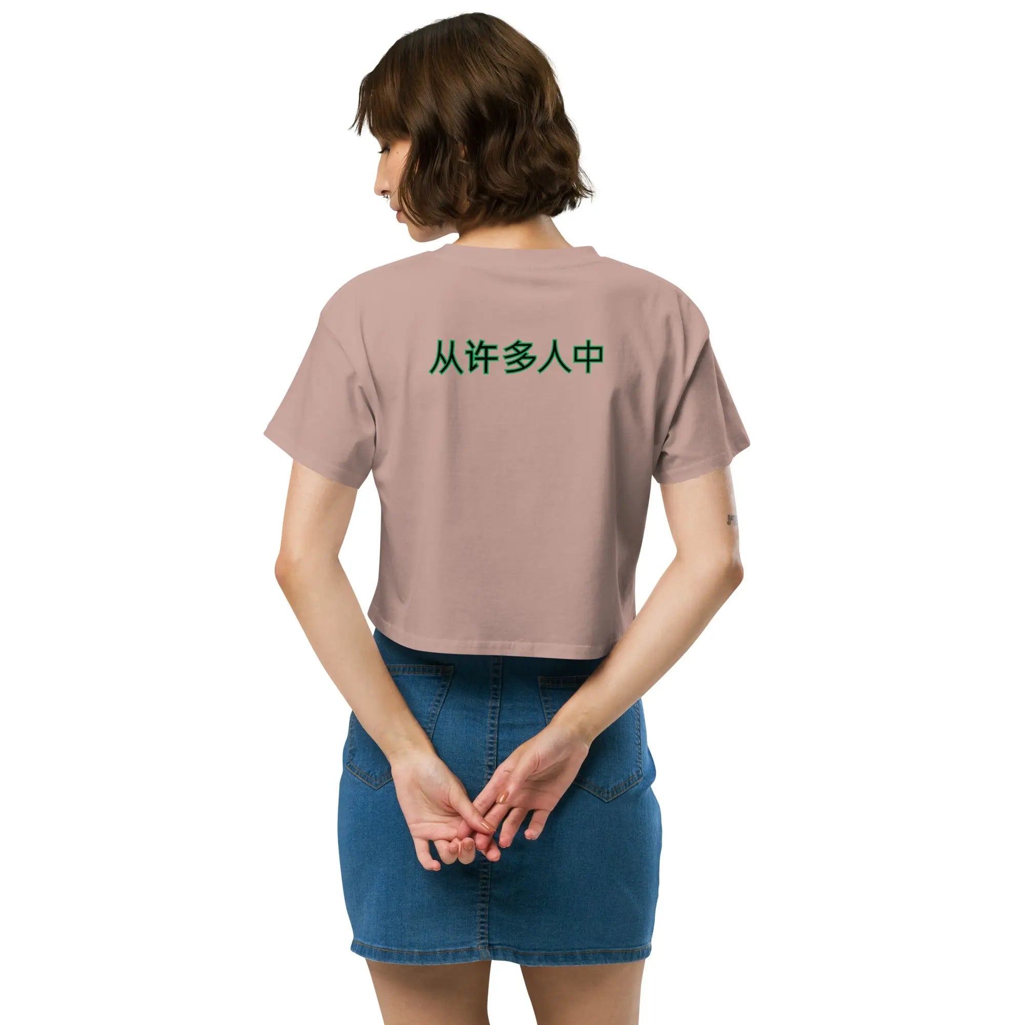 Back view of woman wearing Out Of Many One People crop top with Chinese text on soft pink fabric paired with denim skirt