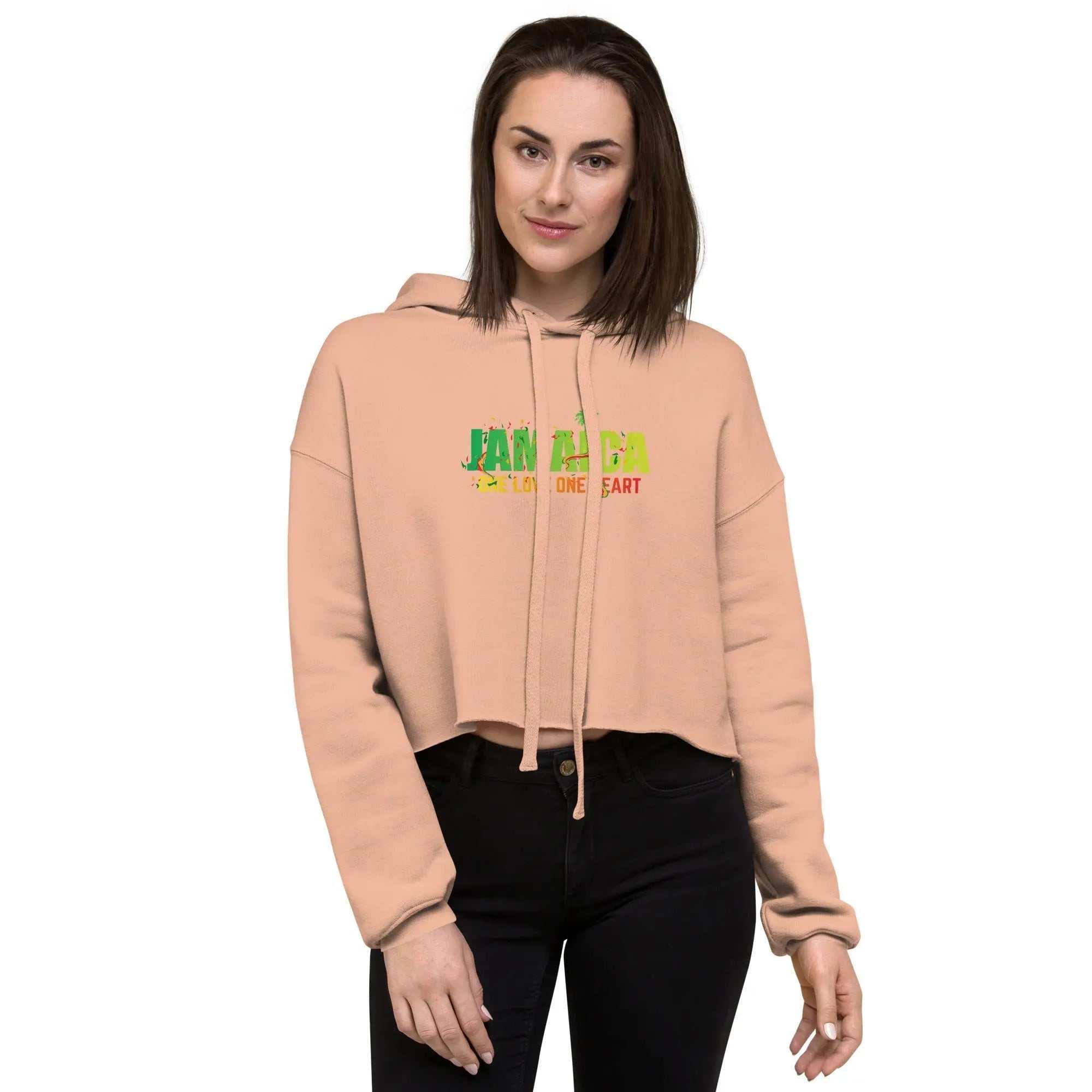 Jamaica One Love One Heart ladies cropped hoodie in peach with green, gold, and red lettering, featuring a relaxed fit and drawstrings.