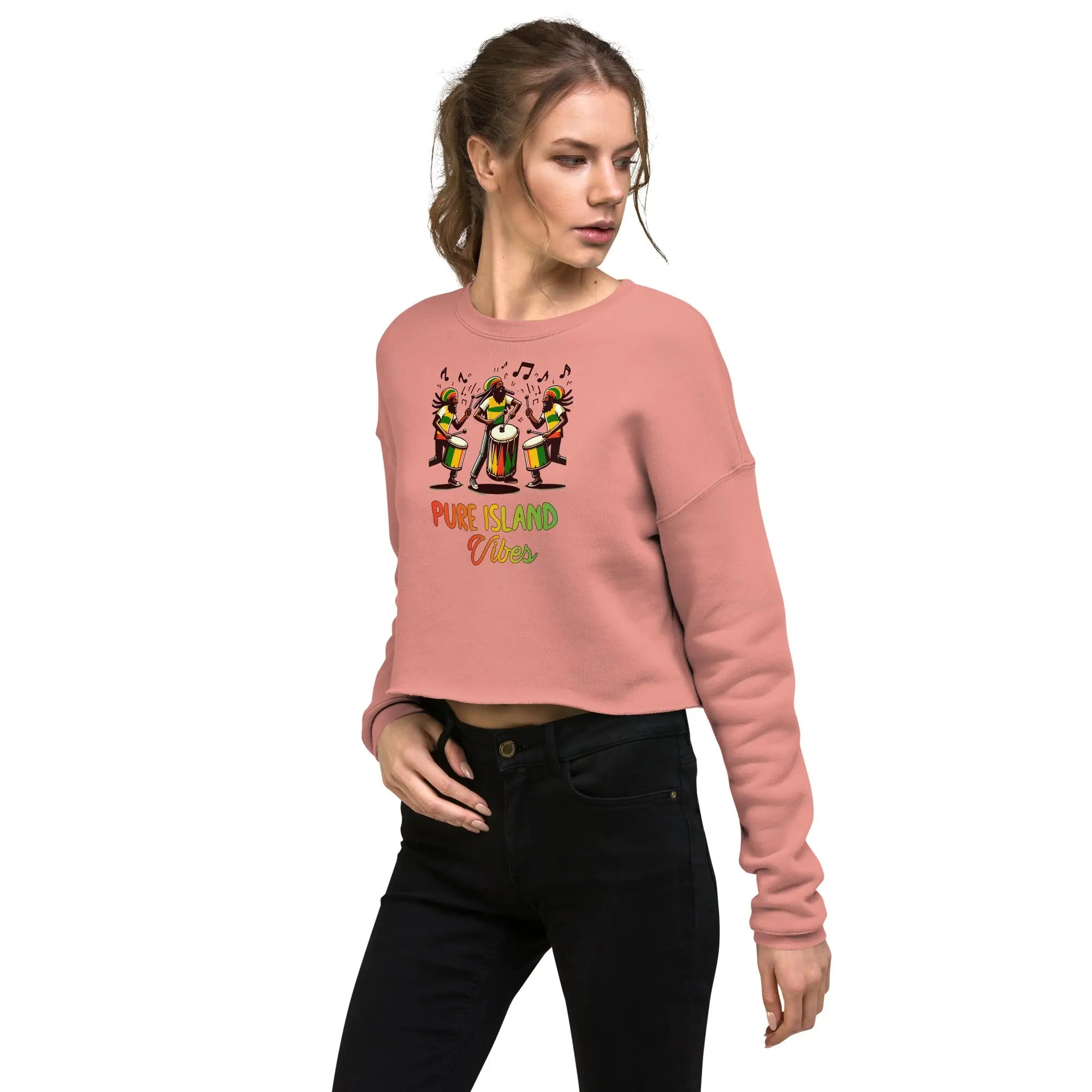 Woman wearing Pure Island Vibes crop sweatshirt with vibrant drummers design on pink fabric